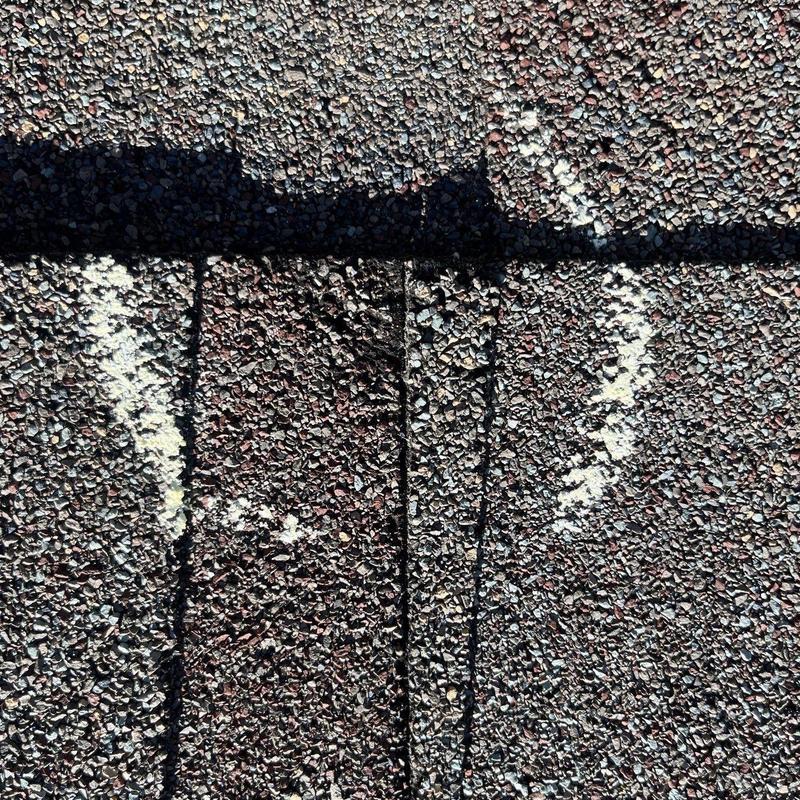 Asphalt shingles with hail damage marks and shadow