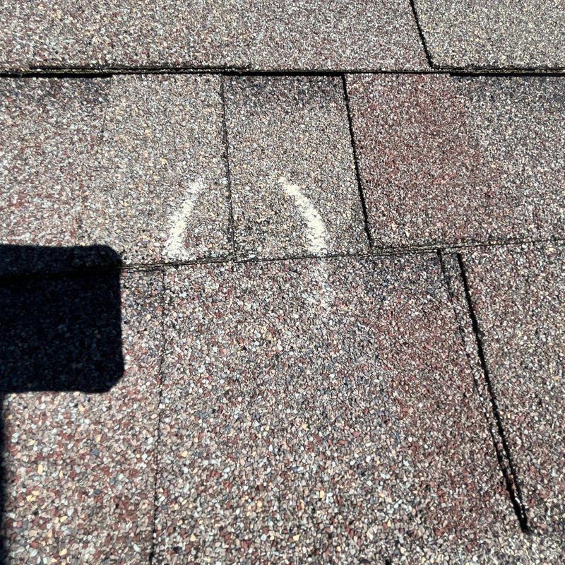Asphalt shingles with marked hail damage on roof