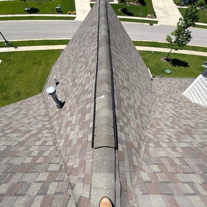 Asphalt shingle roof ridge cap inspection with hail damage