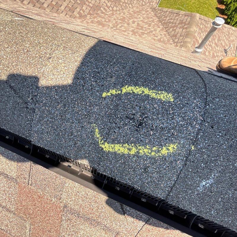 Asphalt shingles with hail damage marked for repair