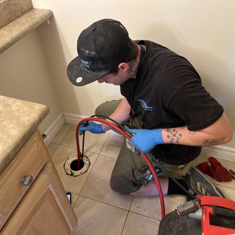 Toilet drain pipe with Roto Rooter inspection in bathroom