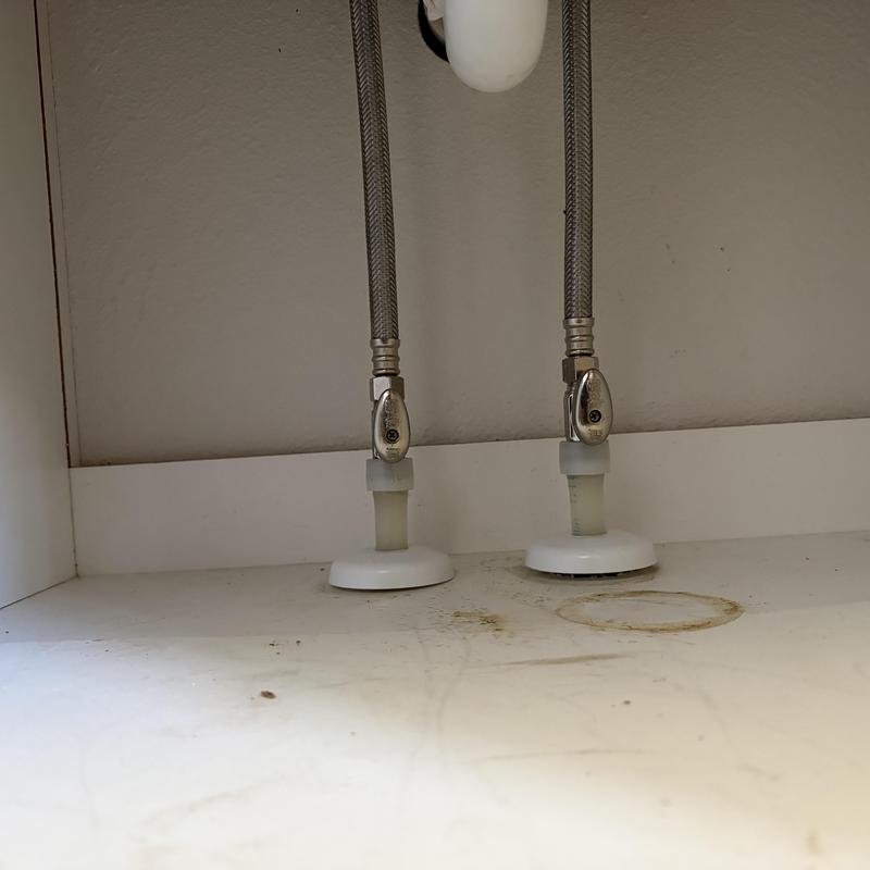 Water supply valve connectors under sink with water stains