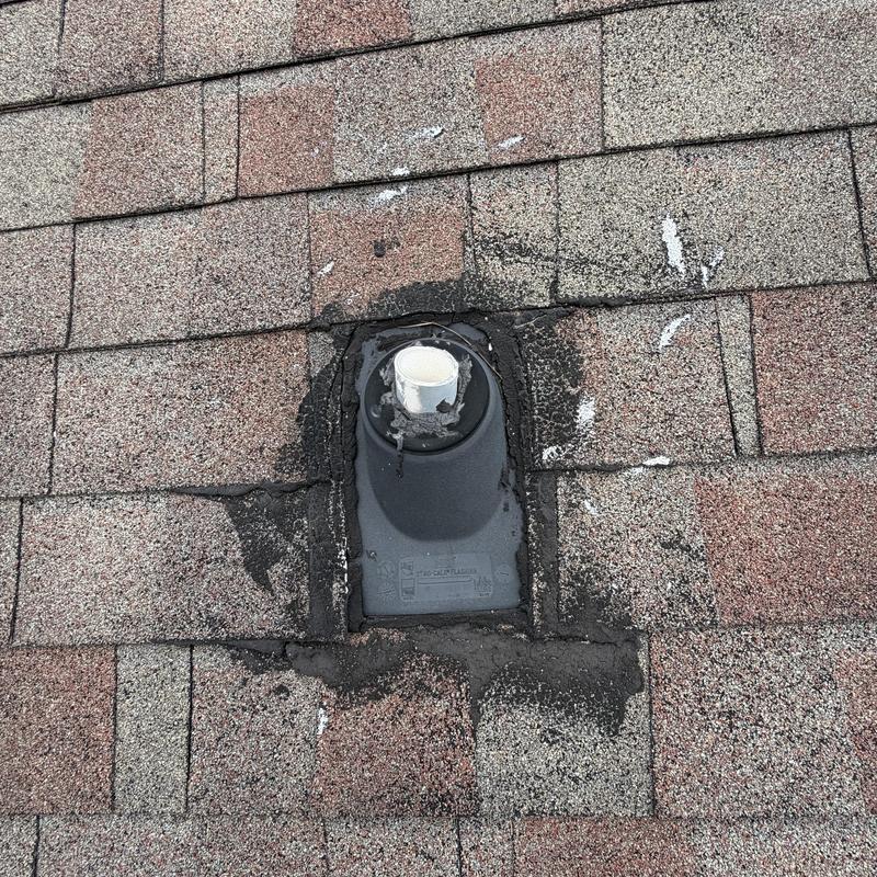 Pipe boot on asphalt shingle roof with sealant patch