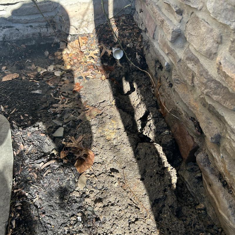 Drain pipe trench excavation next to stone wall Drain pipe trench excavation next to stone wall