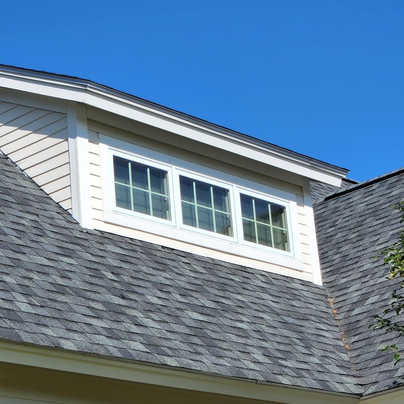 Asphalt shingle roof with dormer window under clear sky Asphalt shingle roof with dormer window under clear sky