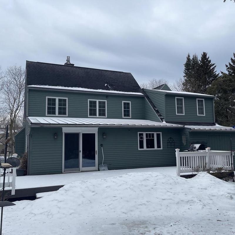 Shingle roof replacement on green two-story house Shingle roof replacement on green two-story house
