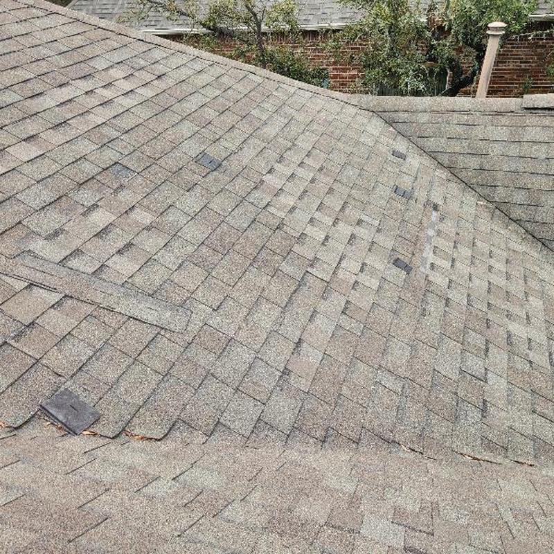 Asphalt shingle roof with missing and slipped shingles