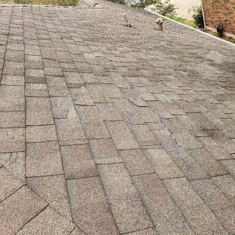 Asphalt shingle roof with missing and slipped shingles