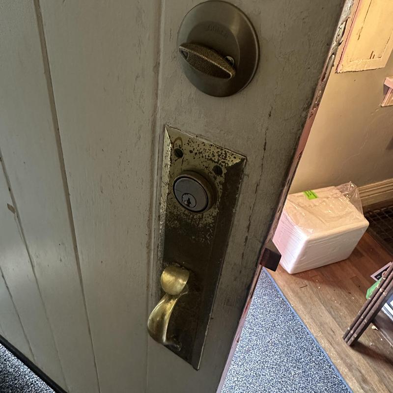 Deadbolt lock installation on wooden door panel