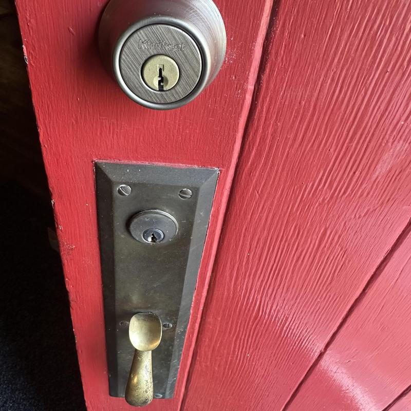 Deadbolt lock and vintage door handle on red wood door
