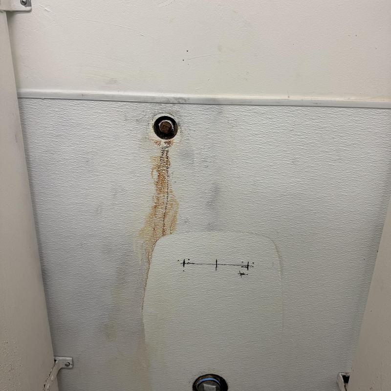 Urinal drain and water line capped in restroom wall