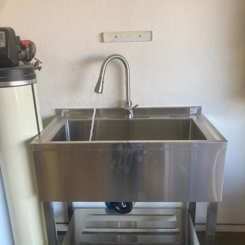 Utility sink with faucet flow in residential room Utility sink with faucet flow in residential room