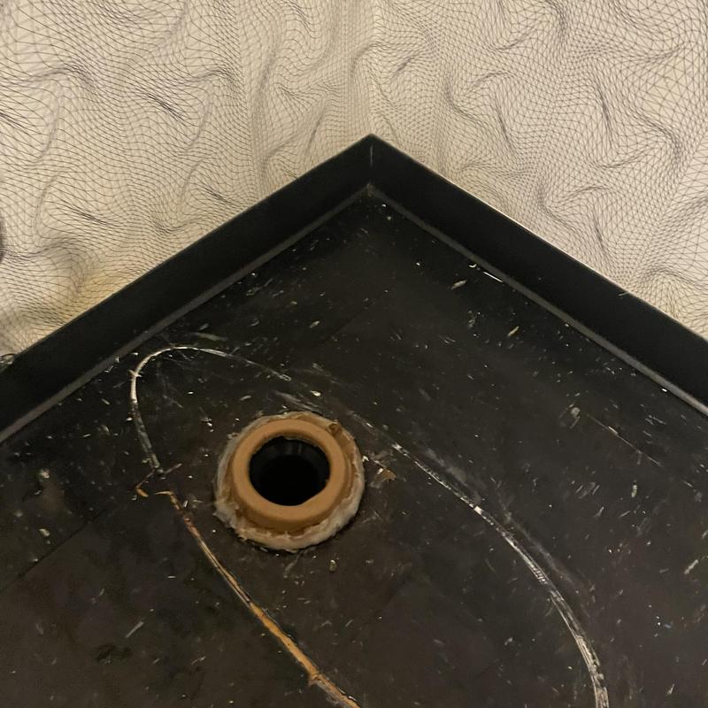 Toilet flange installed on black vinyl floor