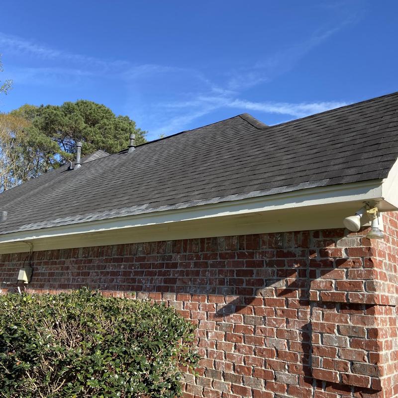 Exterior wood fascia and roof shingles on brick house