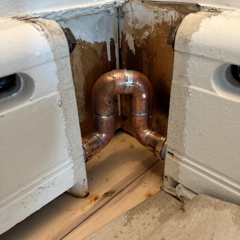 Copper compression line 90-degree bend under cast-iron baseboard