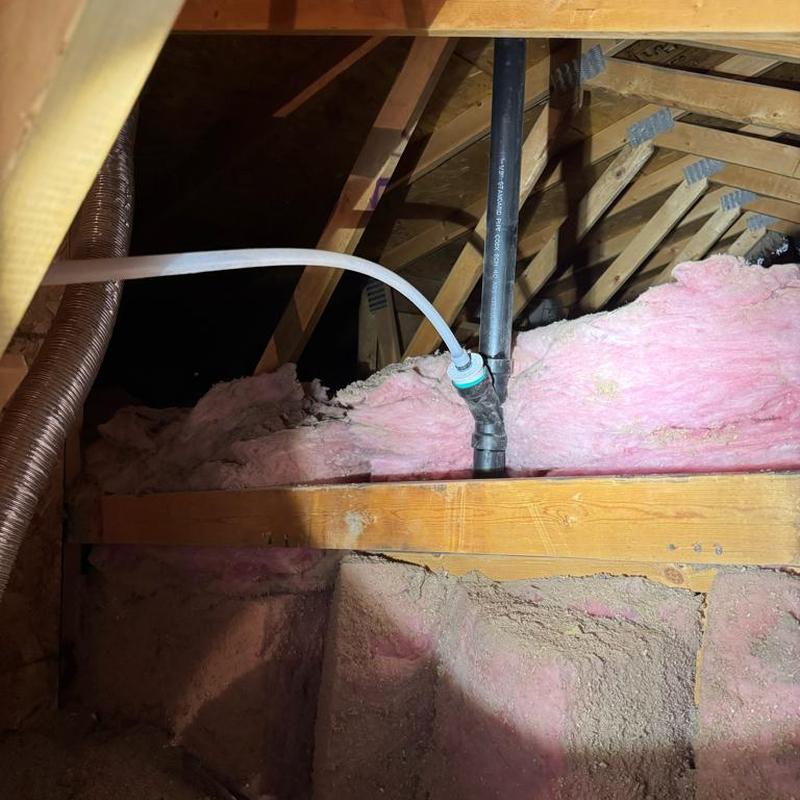 Water softener discharge line with vent pipe in attic