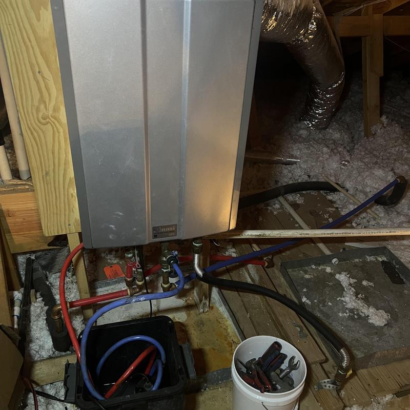 Tankless water heater with flushing tools in attic