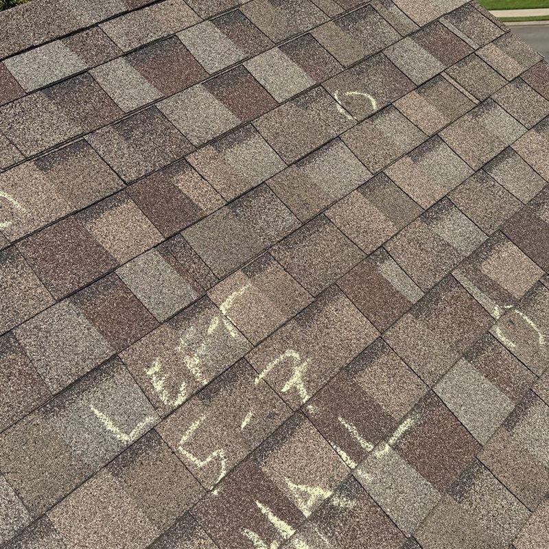 Asphalt roof shingles with hail damage markings
