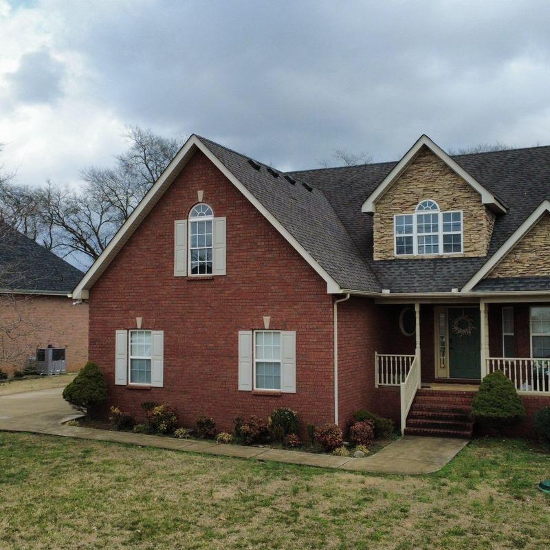 Roof shingles with storm damage on brick house