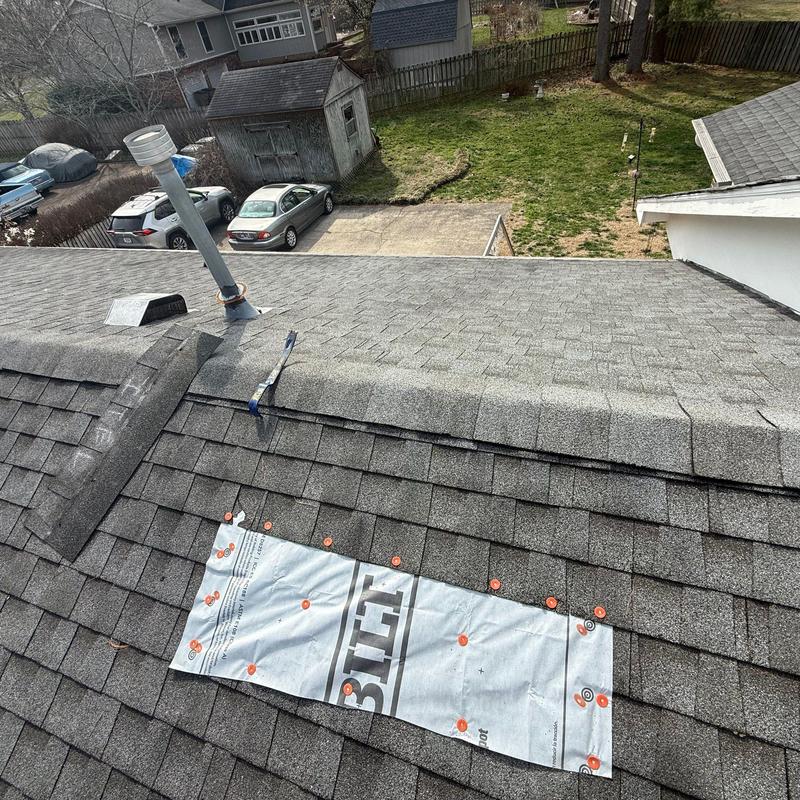 Roof ridge cap with exposed underlayment and damage