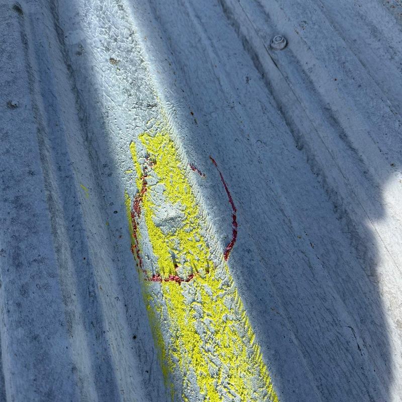 Metal roof panel with hail damage markings