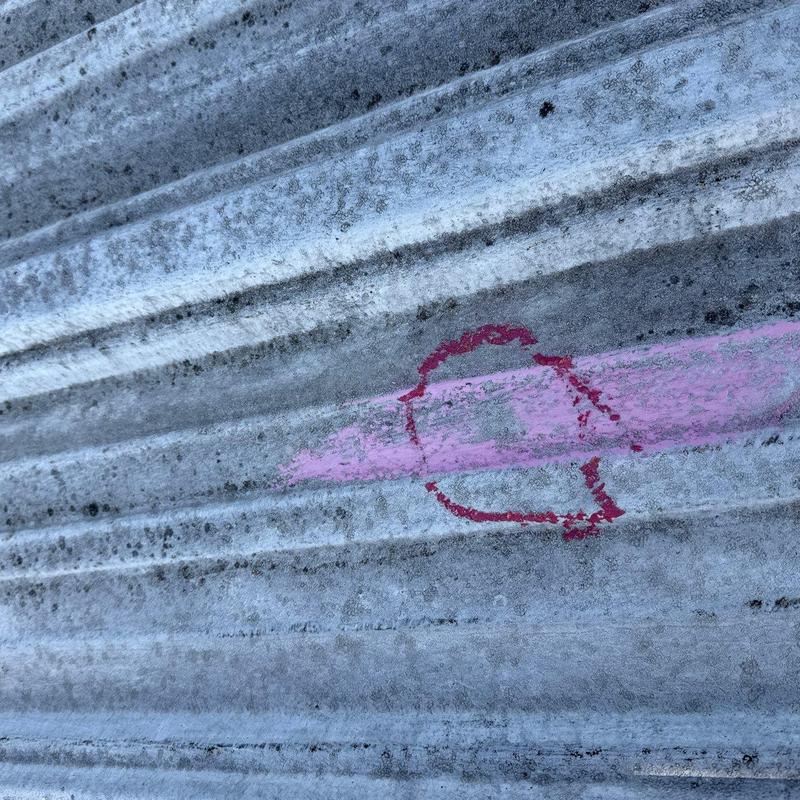 Metal roof hail dent marked for repair