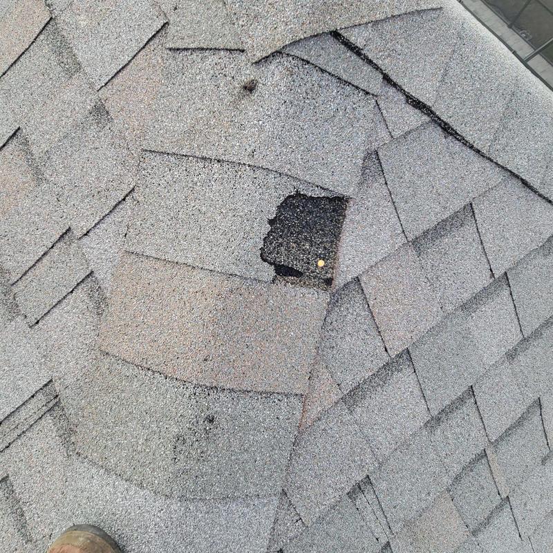 Shingle roof with missing damaged shingle during inspection