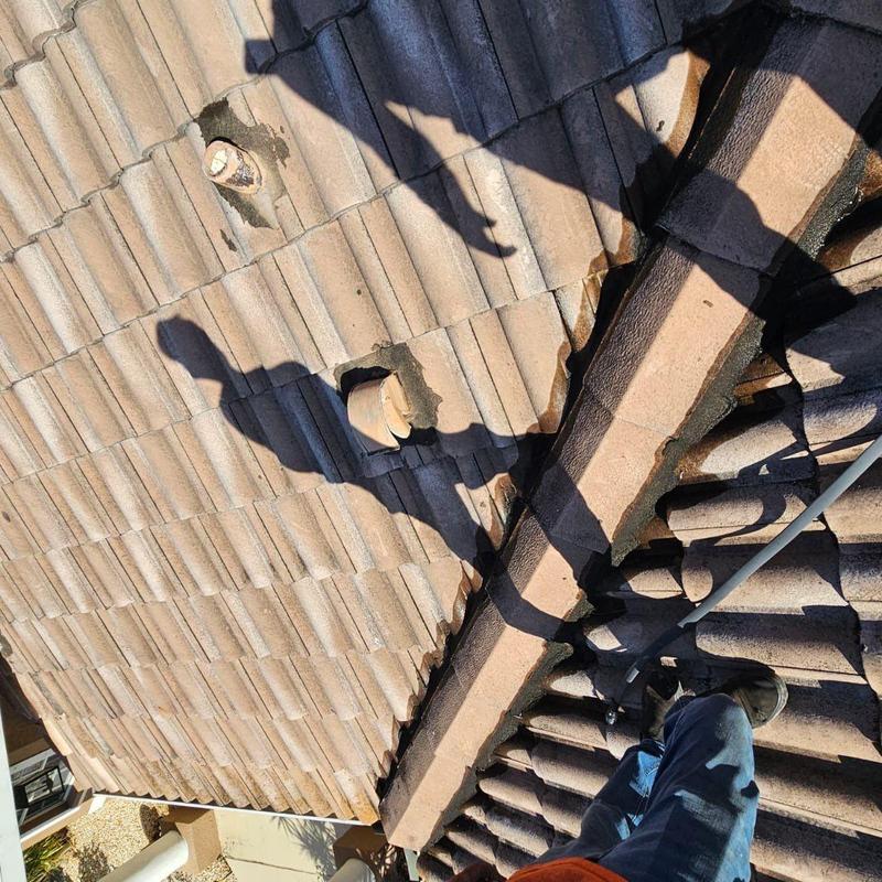 Concrete tile roof with cracked tiles and repair work