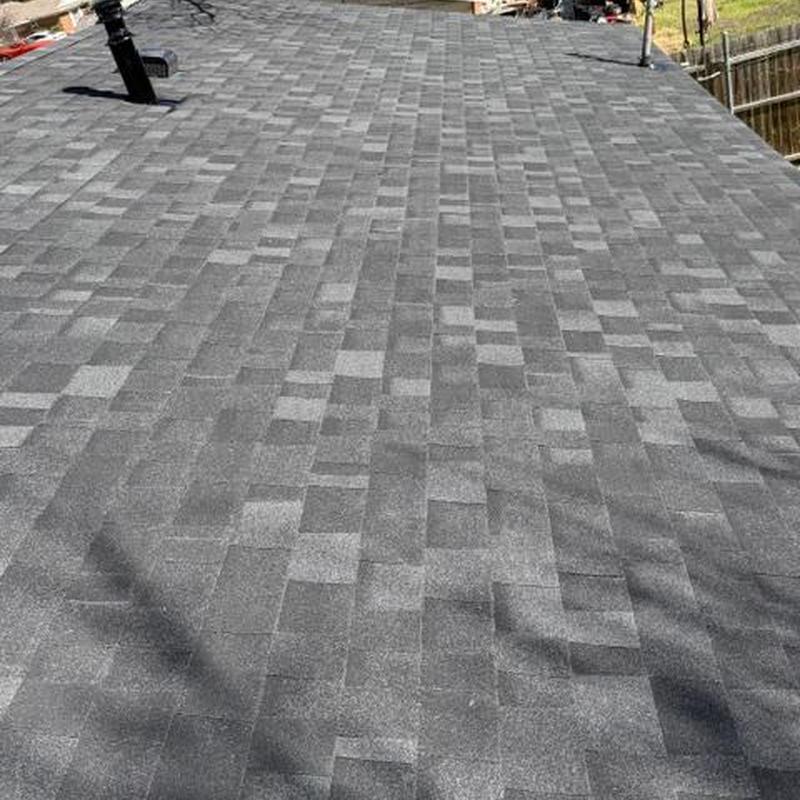 Asphalt shingle roof installation with vent pipe near fence