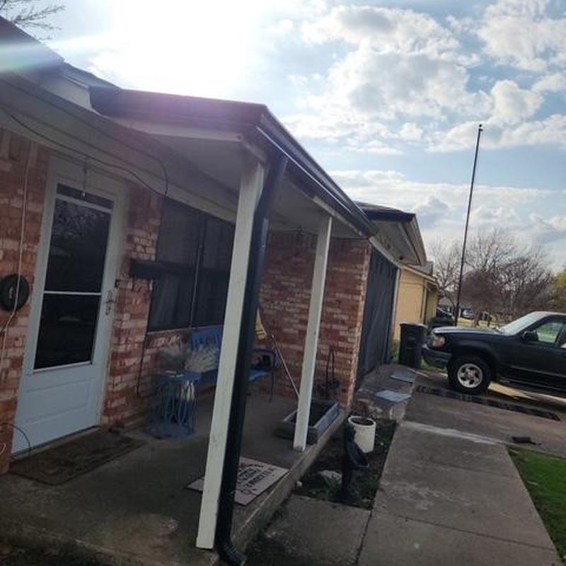 New gutter installation on brick house porch in Fort Worth