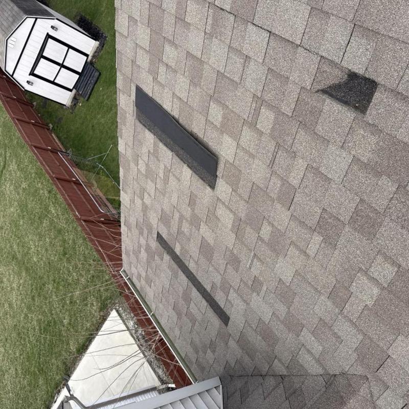 Roof shingles with missing patches after wind storm Roof shingles with missing patches after wind storm