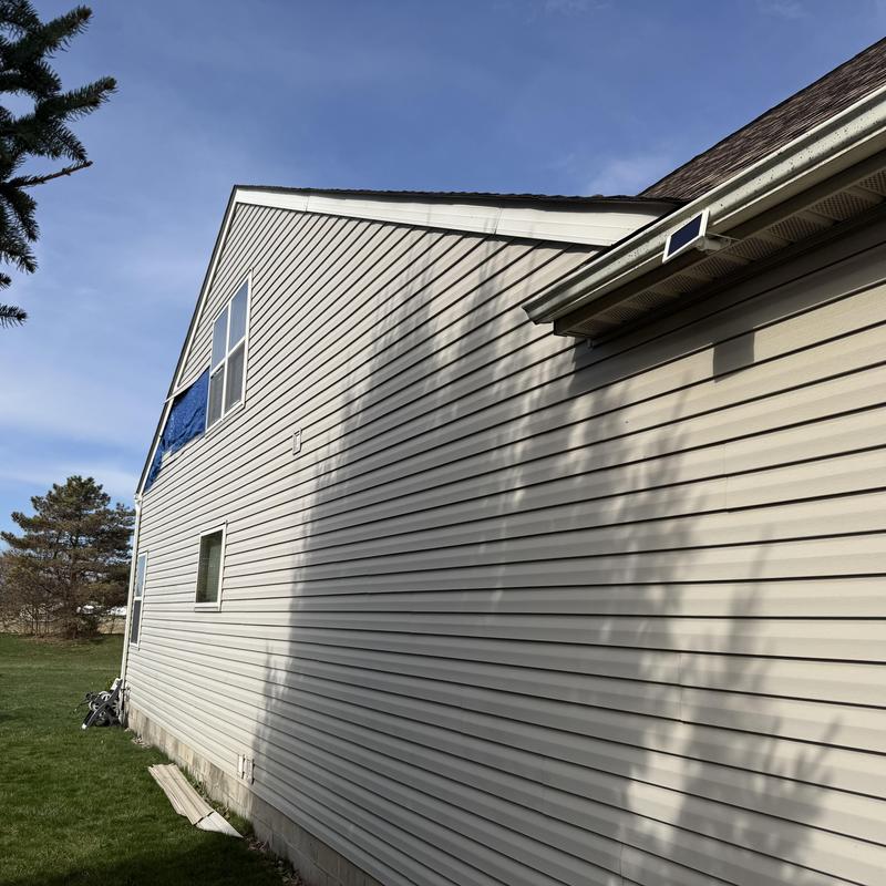 Vinyl siding damage inspection with blue tarp covering Vinyl siding damage inspection with blue tarp covering