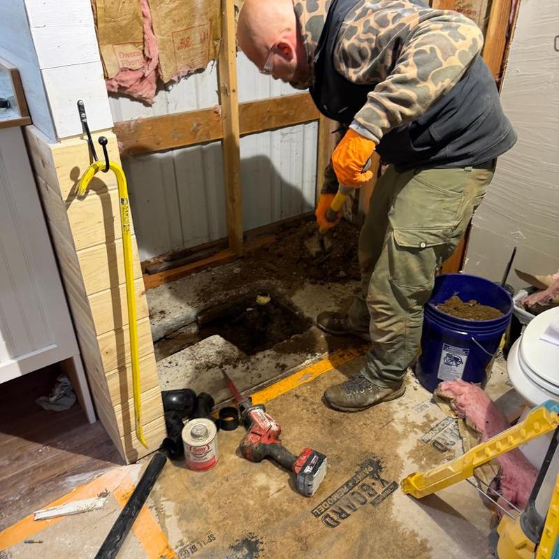 Concrete floor drainage repair with tool and bucket