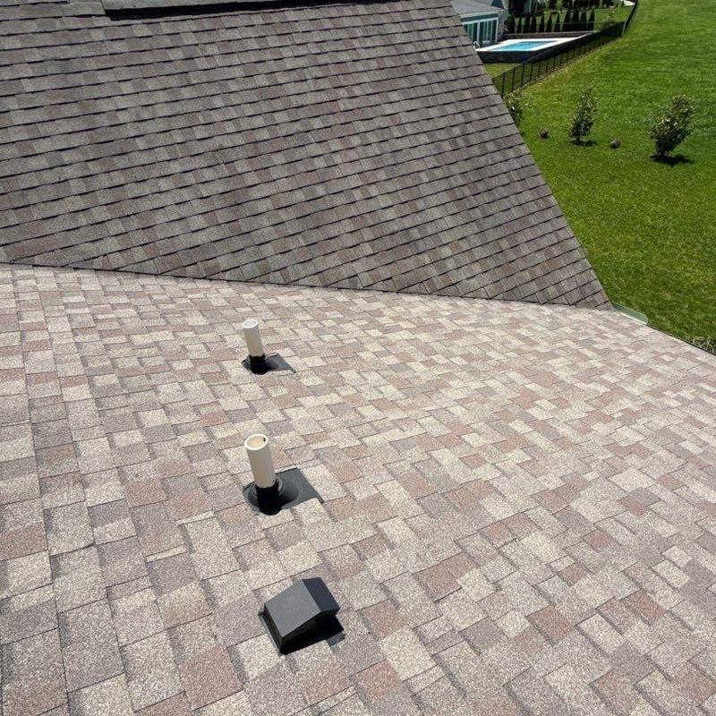 Roof shingles with vent pipe and vent cap on residential roof