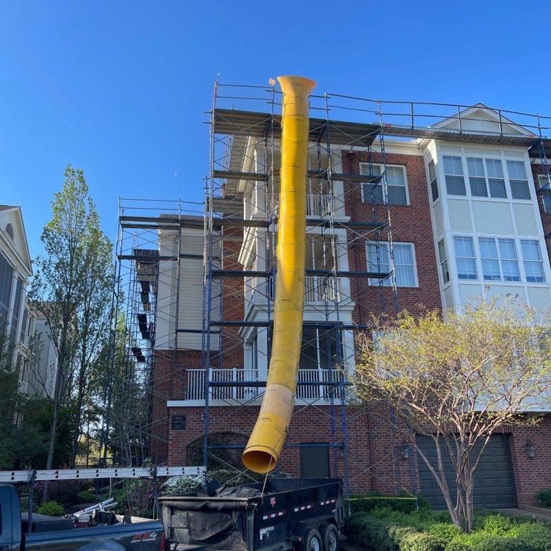 Asphalt shingle roof with scaffolding and debris chute