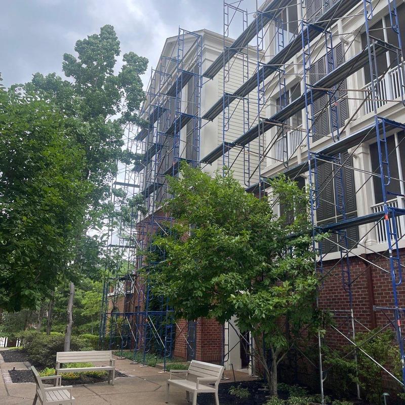 Building exterior scaffolding setup with benches nearby