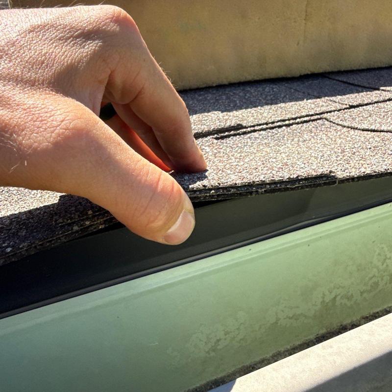 Asphalt shingles lifted on residential roof edge