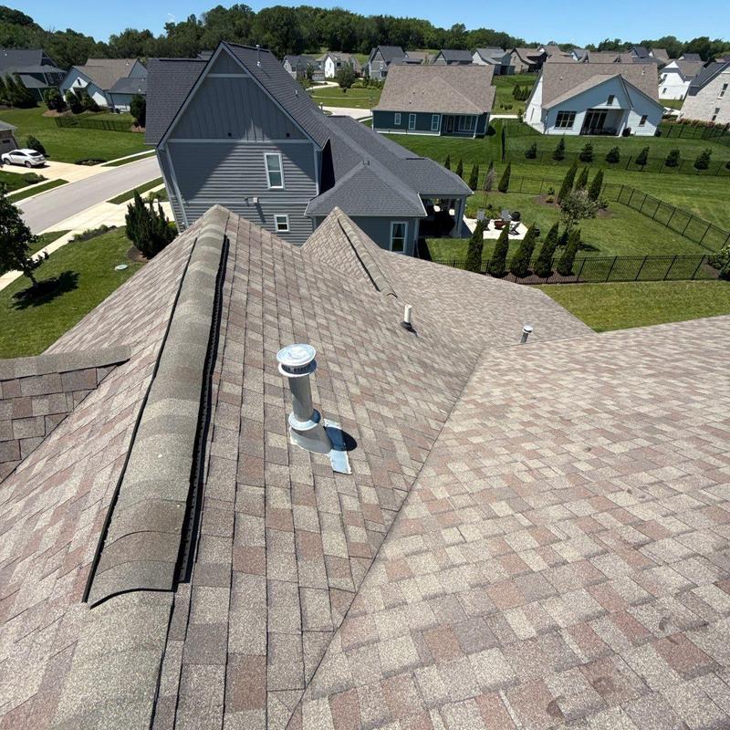 Asphalt shingle roof with ventilation pipe and ridge vent