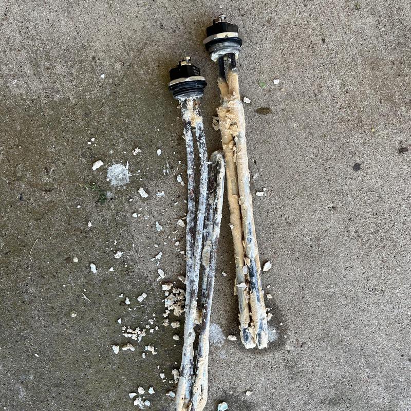 Water heater heating elements coated with mineral buildup