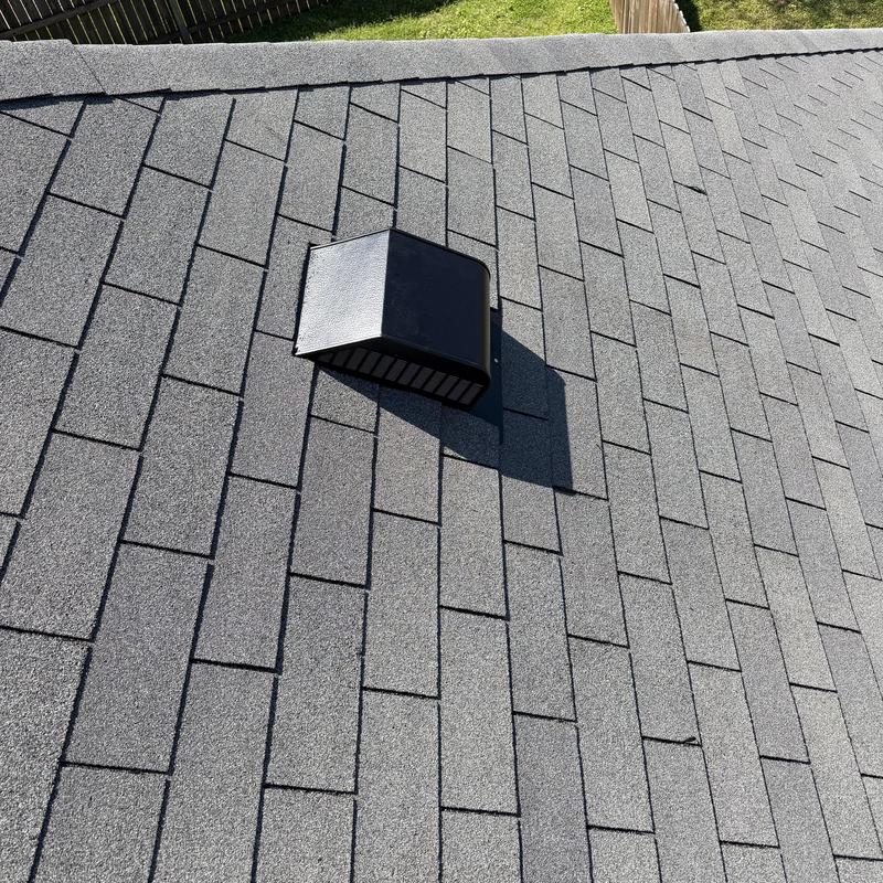 Stove exhaust vent with black vent cap on roof