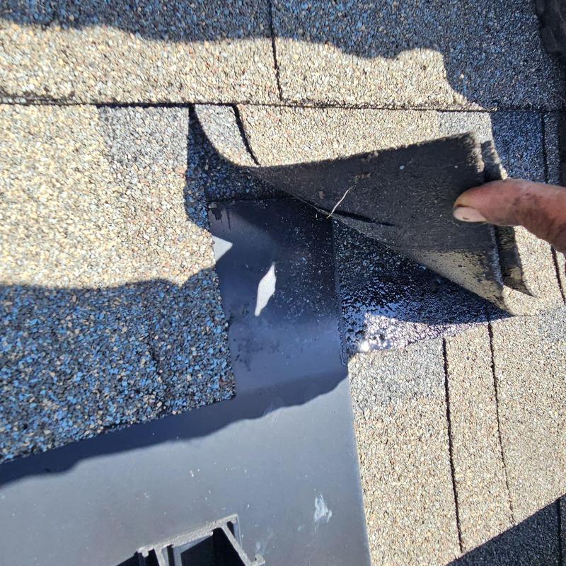 Roof shingle lifted to expose damaged underlayment and sealant