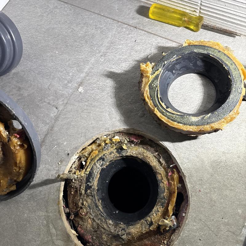Toilet flange with old wax ring removed on floor