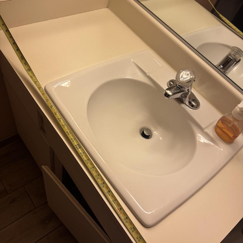 Bathroom sink with faucet and countertop measuring tape