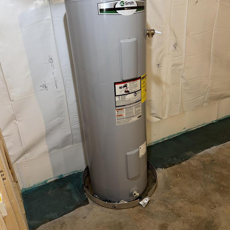 Electric water heater tank with spill pan installed