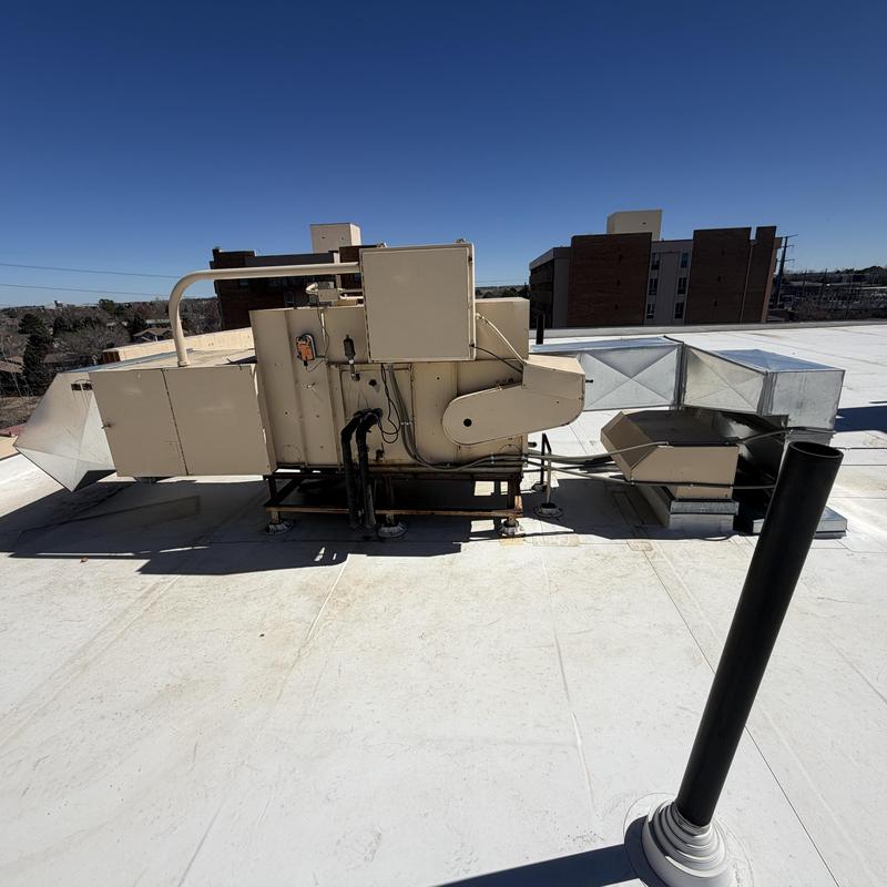Rooftop HVAC unit with ductwork on flat roof