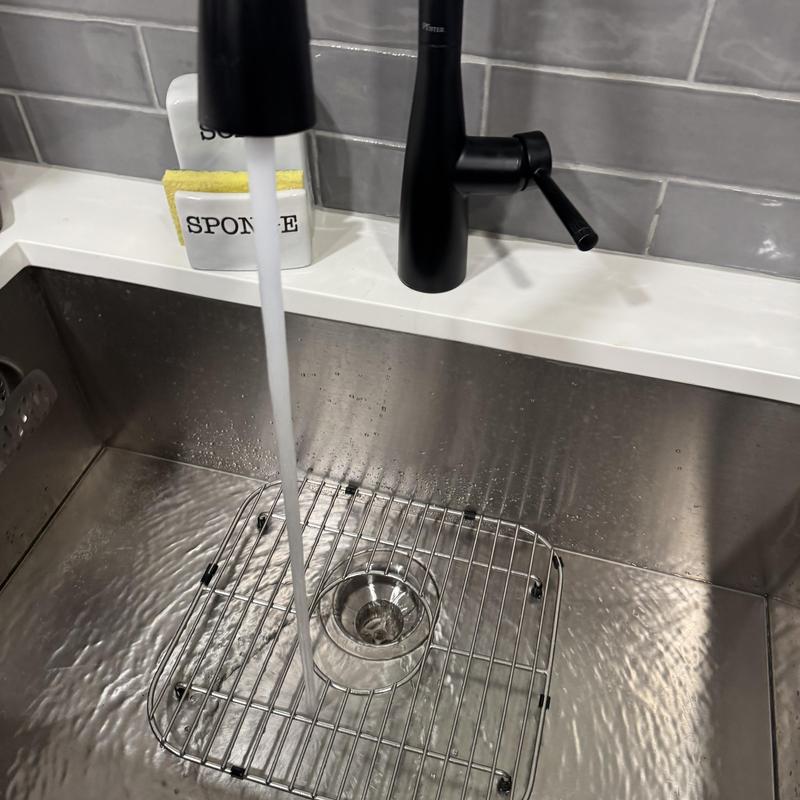 Kitchen sink drain with water running and grid rack