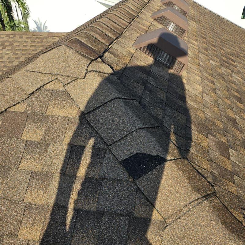 Shingle roof with cracked and damaged shingles near vents
