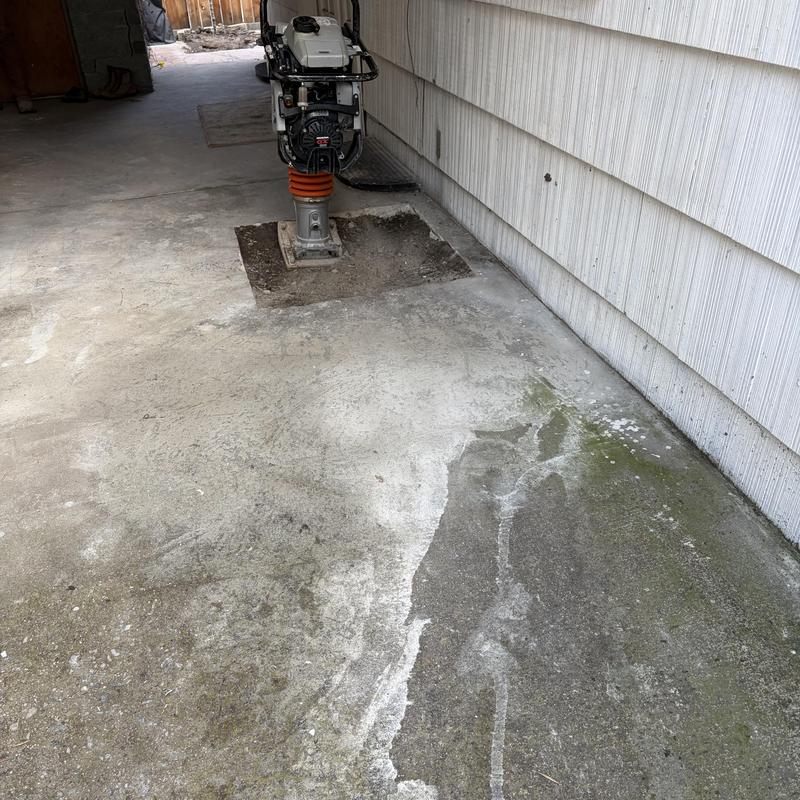 Sewer main excavation with compactor on concrete slab Sewer main excavation with compactor on concrete slab