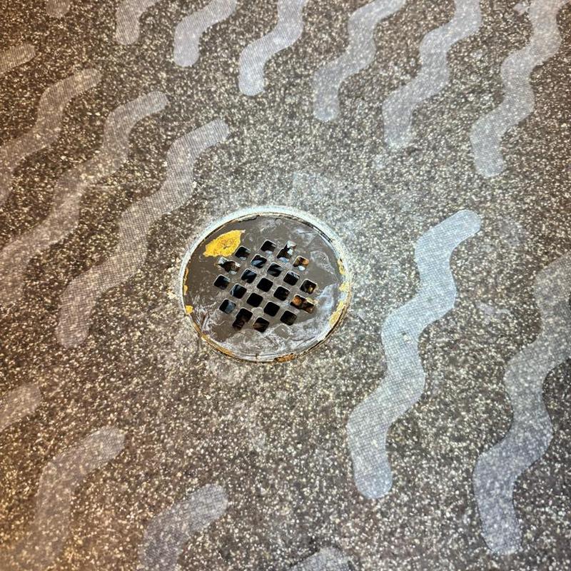 Shower drain cover with worn floor sealant Shower drain cover with worn floor sealant