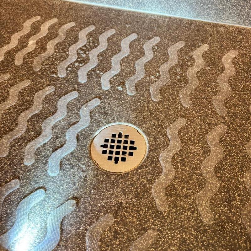 Shower drain cover on textured shower floor Shower drain cover on textured shower floor